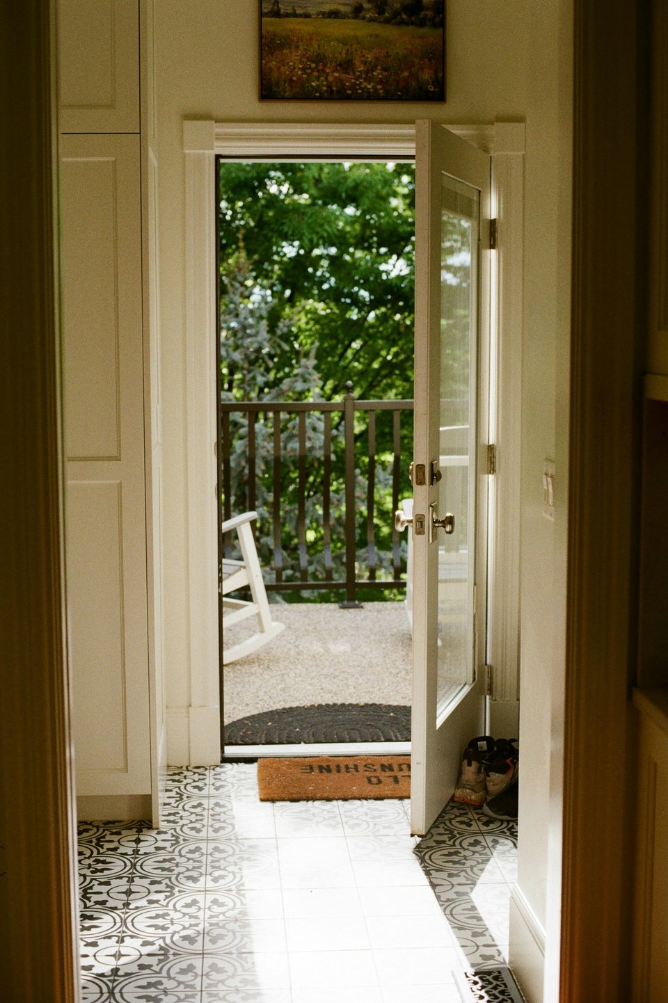 An open doorway leading to a sunny porch