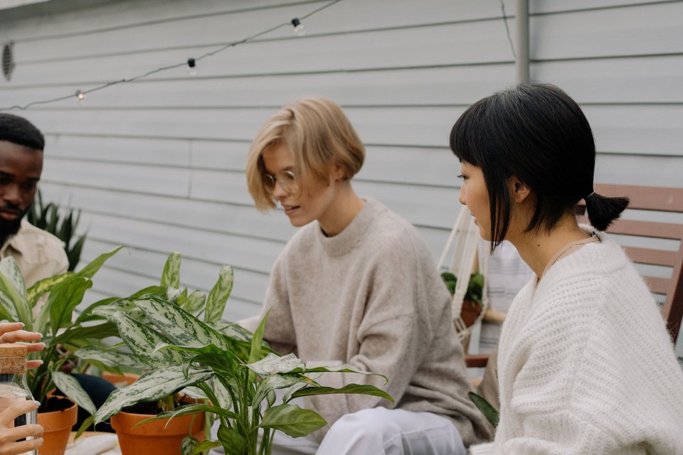Adults potting plants together outdoors